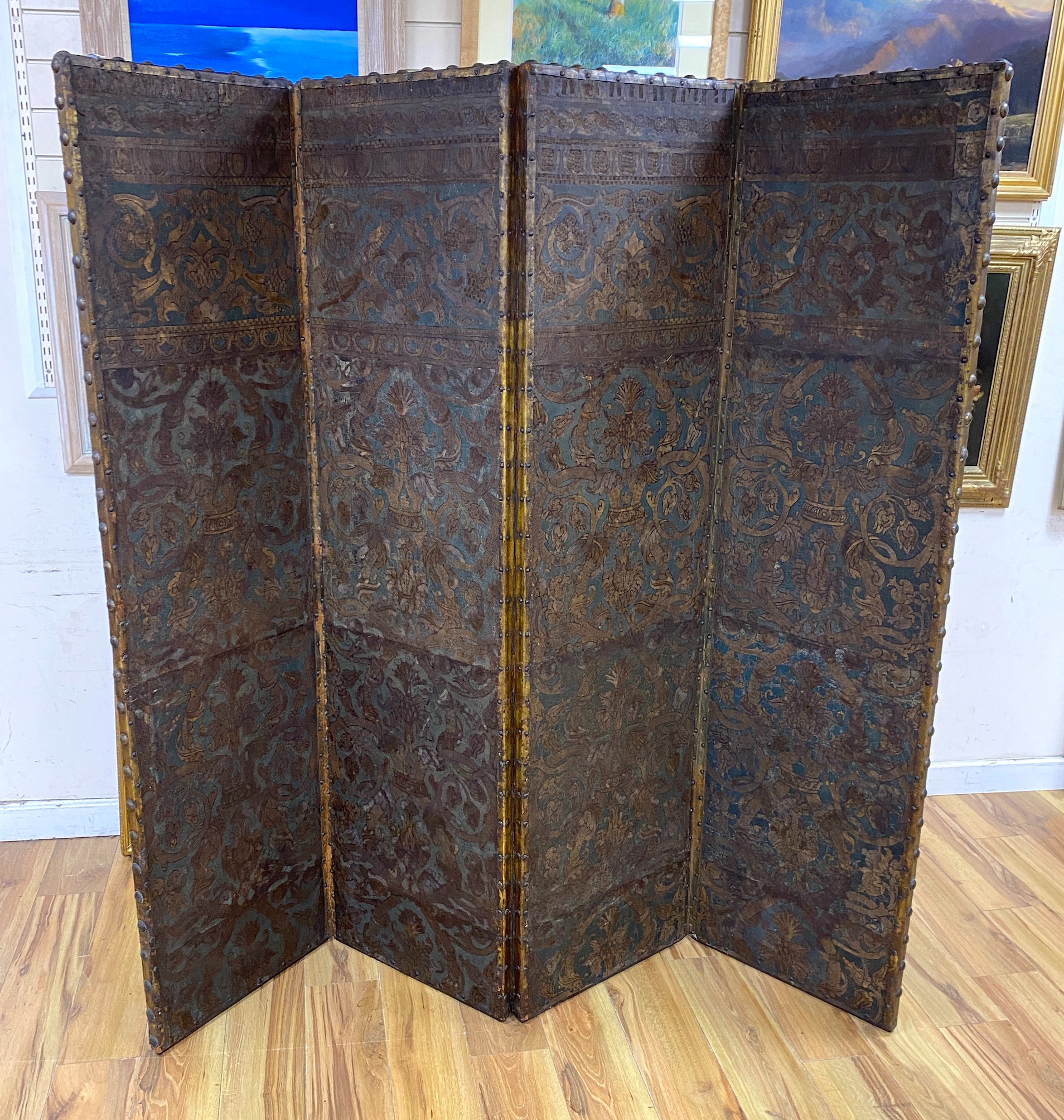 A 19th century French studded leather four fold screen, each panel width 49cm, height 182cm